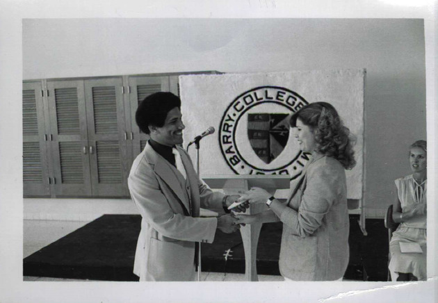 Graduating honor student Michael A. King presents an award to Dalila Hernandez at the 1980 Honors Reception Awards